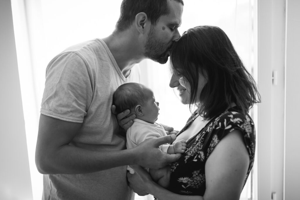 Photographe maternité en Seine-et-Marne papa et maman portant nouveau né