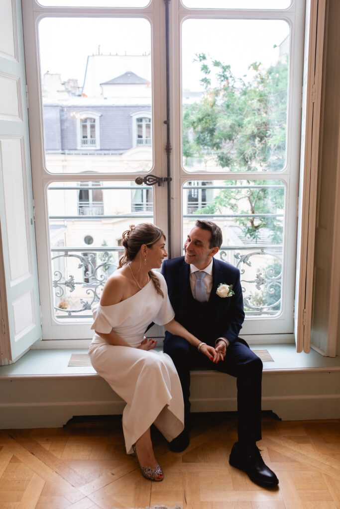 Photographe mariage Paris mariés devant fenêtre